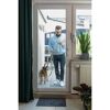 Person mit Hund und Smartphone an der Terrassentür
