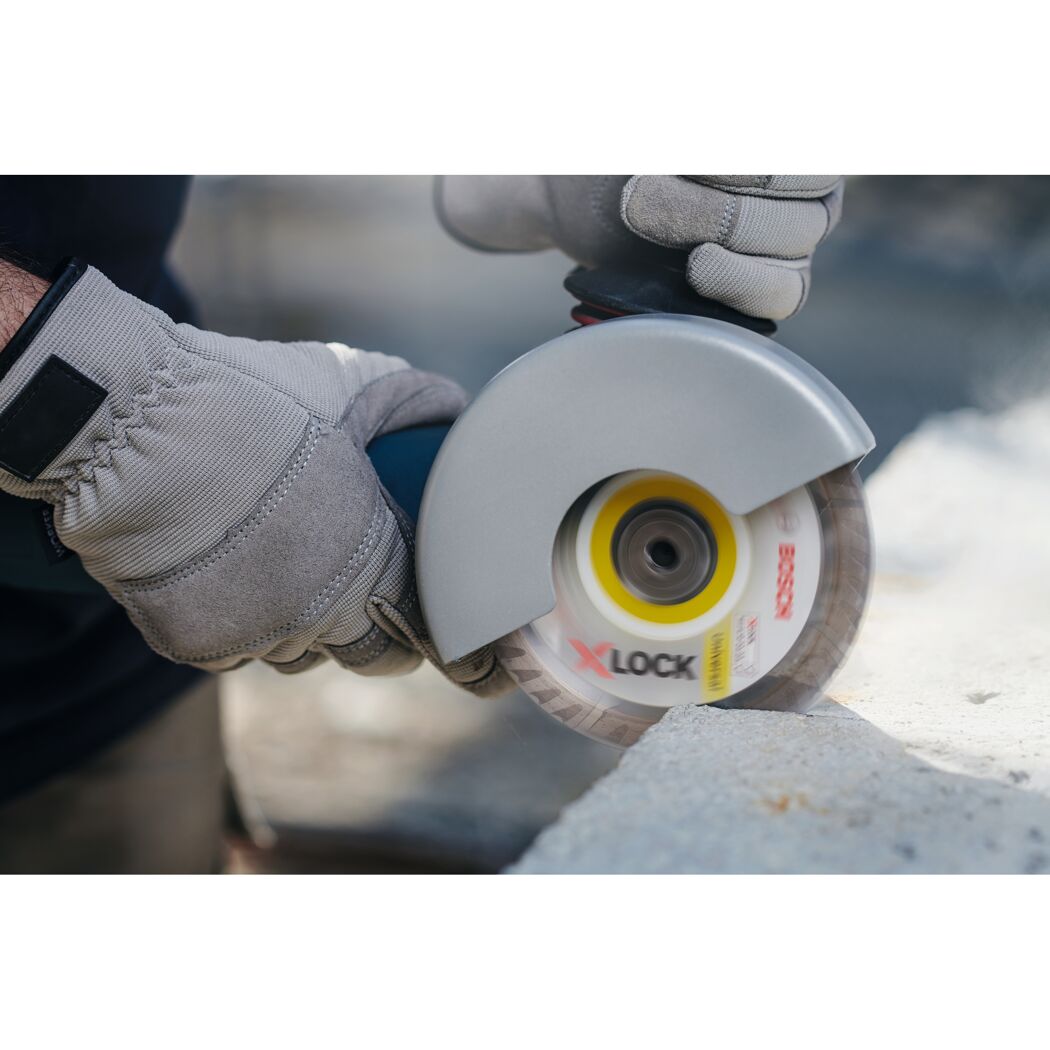 Person schneidet Beton mit einem Winkelschleifer.