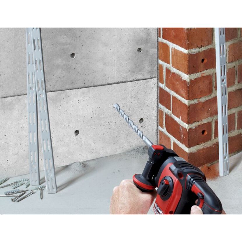 Person bohrt mit einem Bohrhammer in eine Betonwand.