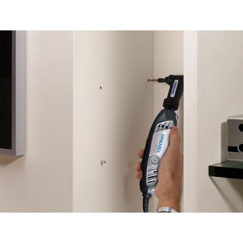 Person bohrt mit einem Dremel 3000 mit Winkelaufsatz ein Loch in die Wand.