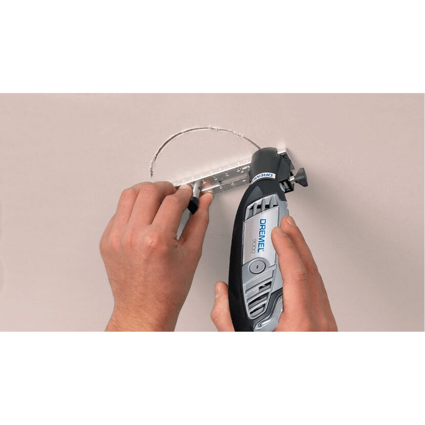 Person schneidet mit einem Dremel ein Loch in die Decke.