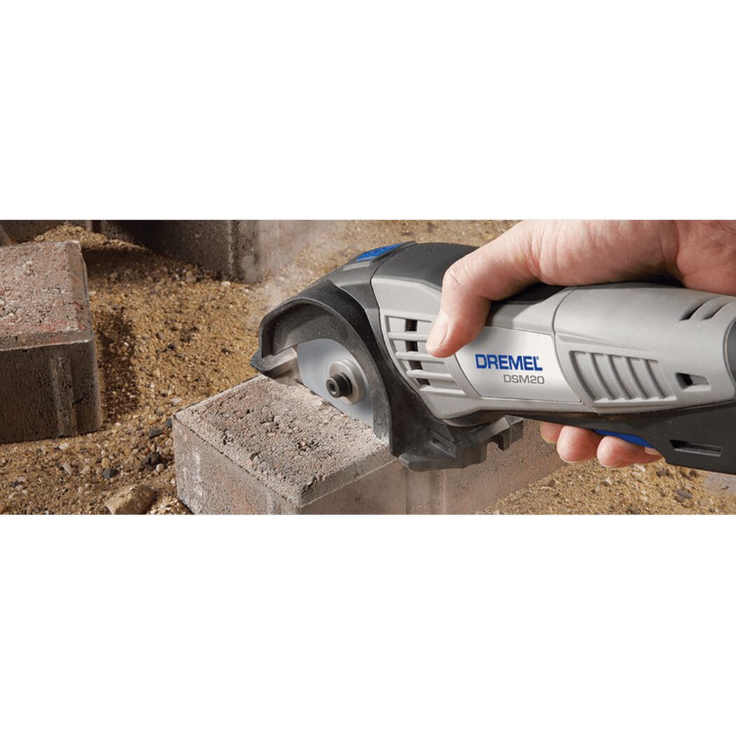 Person schneidet mit einem Dremel DSM20 einen Ziegelstein.