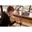Person bearbeitet Modellschiff mit Dremel Werkzeug.
