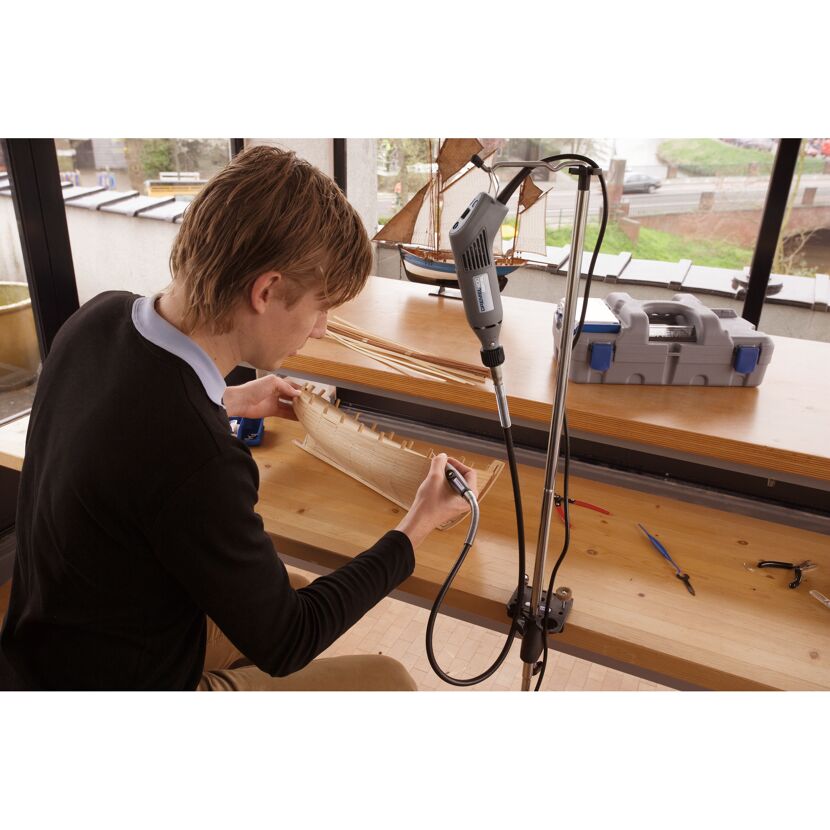 Person bearbeitet Modellschiff mit Dremel Werkzeug.