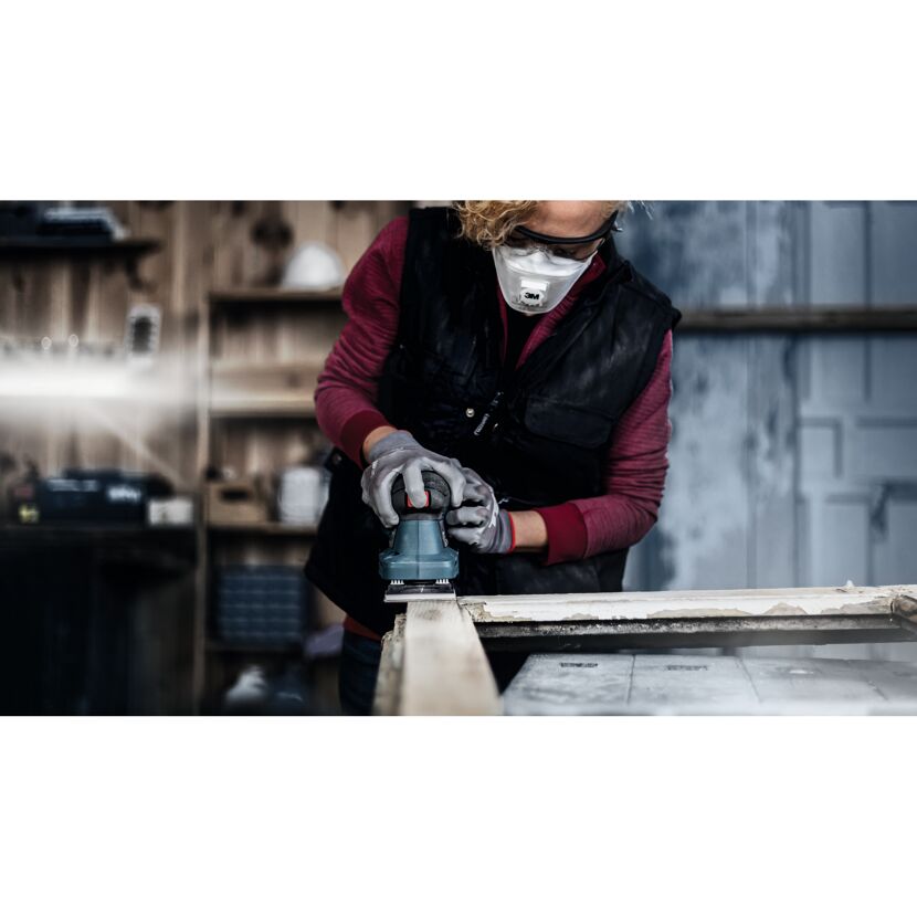Person schleift Holz mit Schleifmaschine