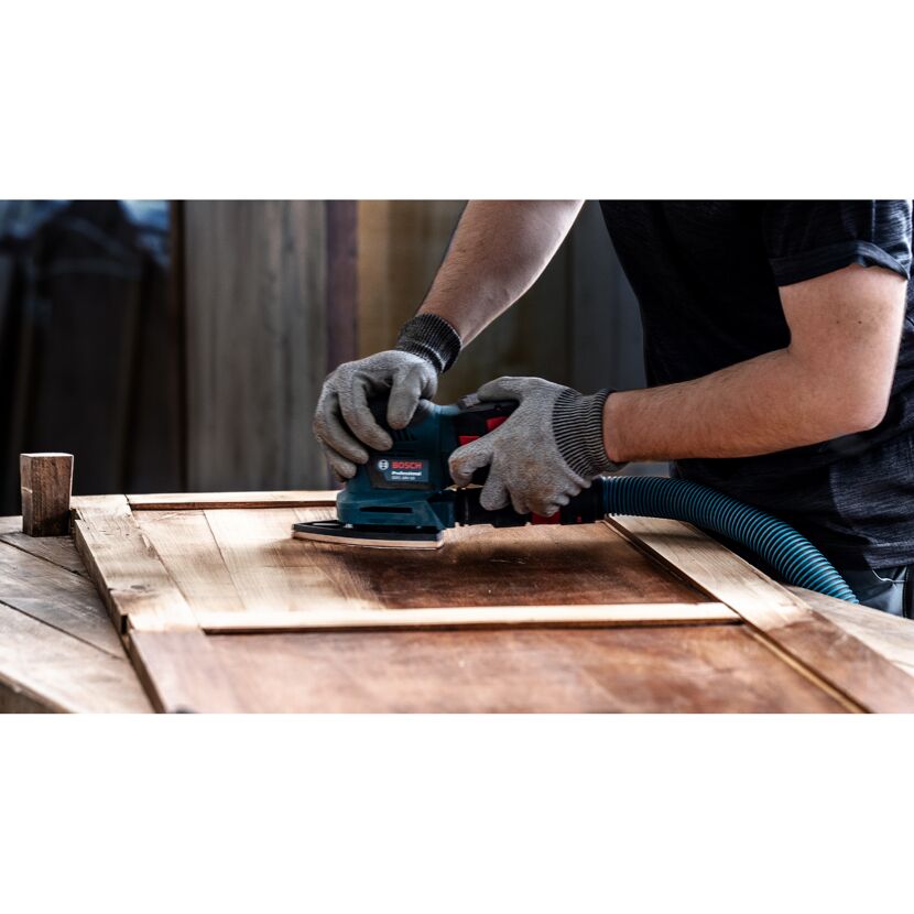 Person schleift Holz mit einem Bosch-Schleifer.