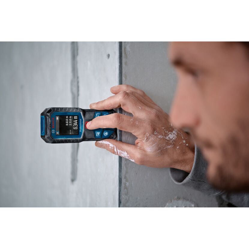 Person misst eine Wand mit dem Bosch Laser-Entfernungsmesser GLM 50-22.