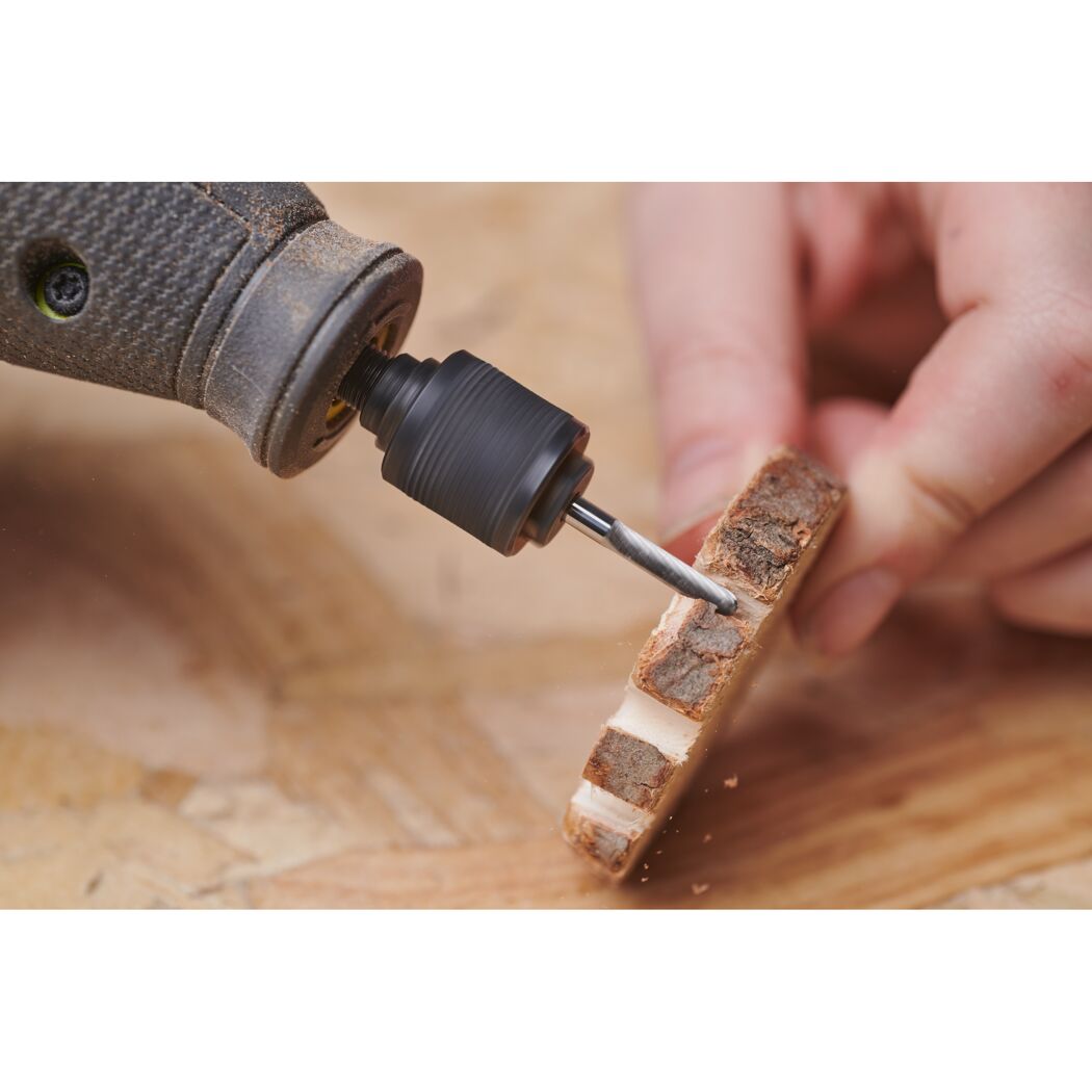 Person fräst mit Fräse ein Stück Holz