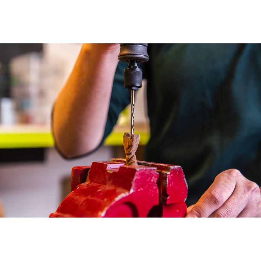 Person bohrt mit Bohrmaschine in Holz