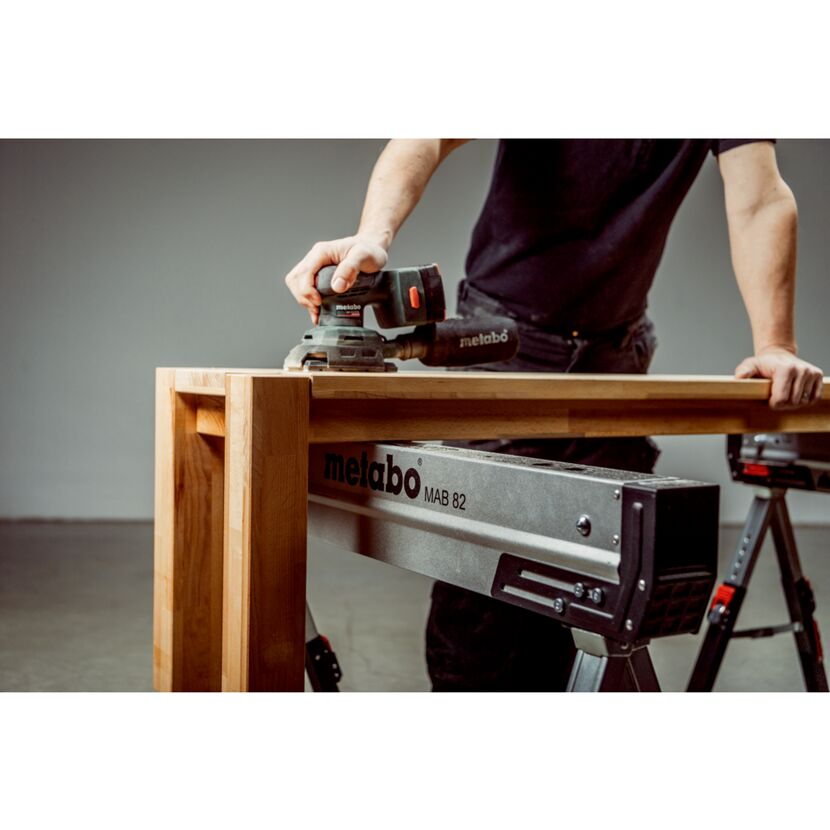 Person schleift Holz mit Schwingschleifer
