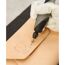 Person graviert mit einem Dremel ein Lederstück.