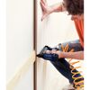 Person befestigt Holzpaneel mit Drucklufttacker an Wand.