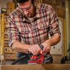Person hobelt Holz mit Elektrohobel