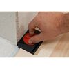 Person verwendet Abstandhalter beim Verlegen von Laminat.
