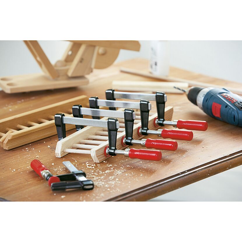 Werkbank mit Schraubzwingen, Holz und Akkuschrauber