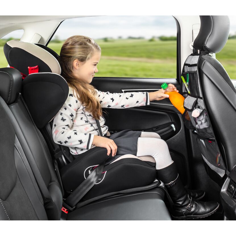 Kind im Autositz trinkt