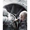 Person repariert einen Flugzeugmotor mit einem Schraubendreher.