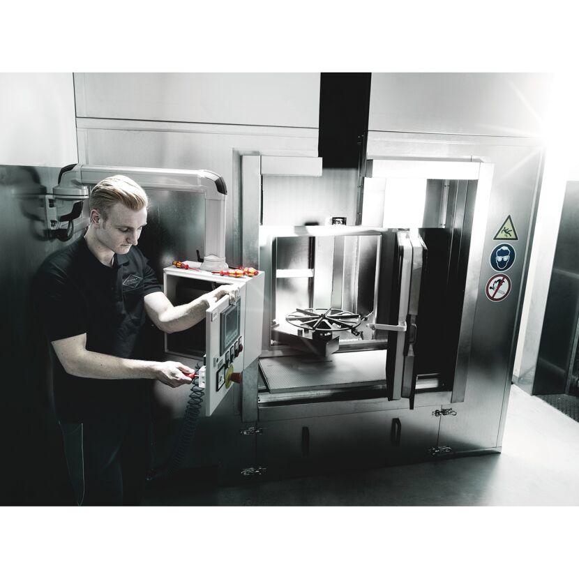 Person bedient eine industrielle Maschine.