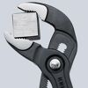Knipex Cobra Wasserpumpenzange hält einen Metallwürfel