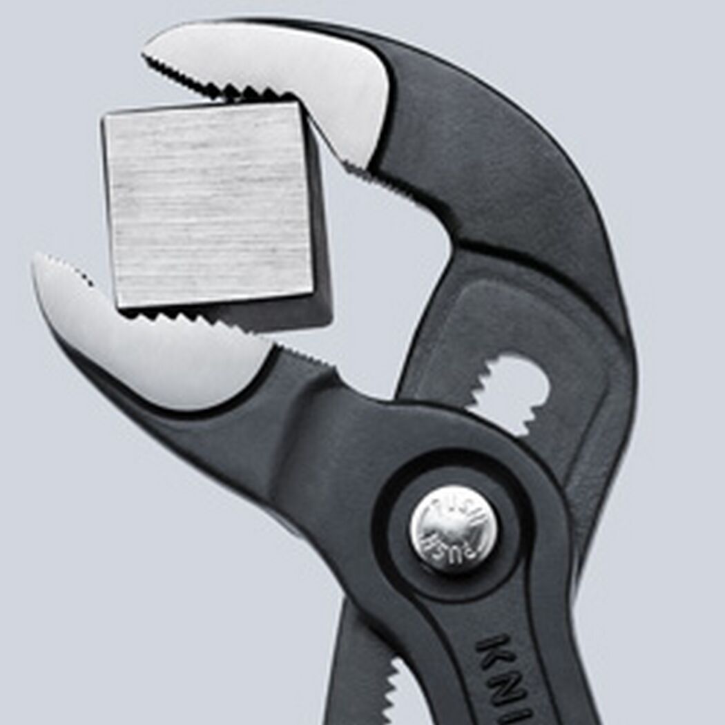 Knipex Cobra Wasserpumpenzange hält einen Metallwürfel