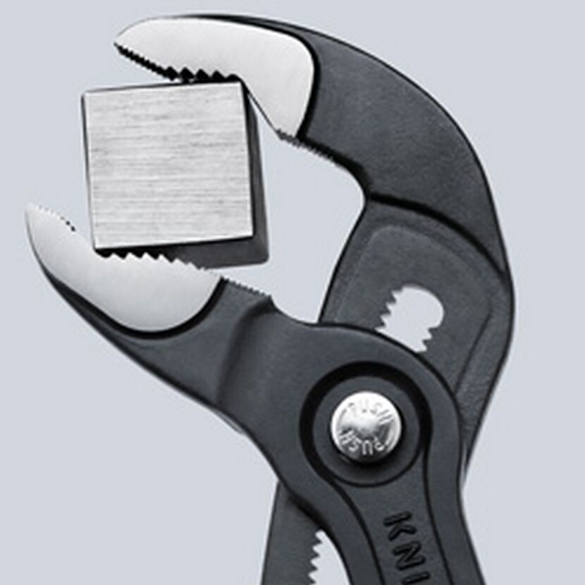 Knipex Cobra Wasserpumpenzange hält einen Metallwürfel