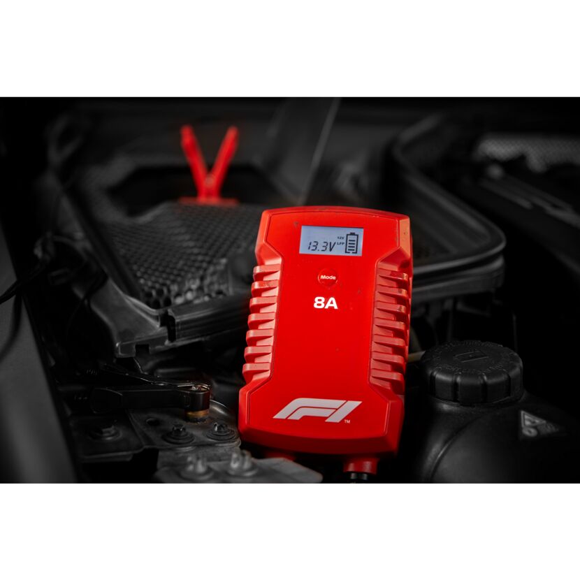 Rotes Batterieladegerät von Formula 1 an Autobatterie angeschlossen