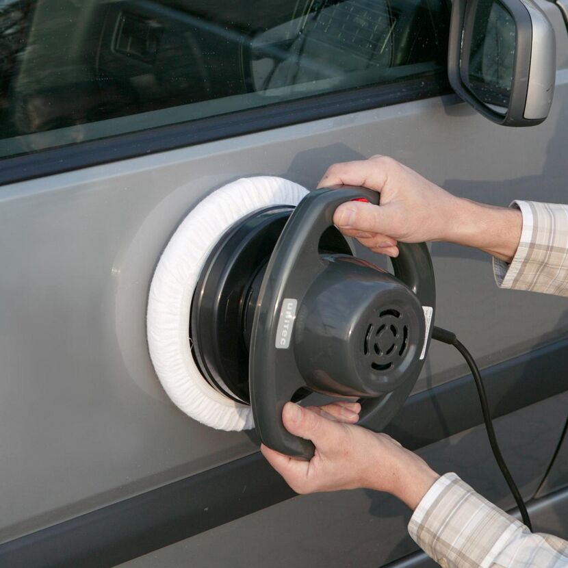 Person poliert Auto mit Poliermaschine