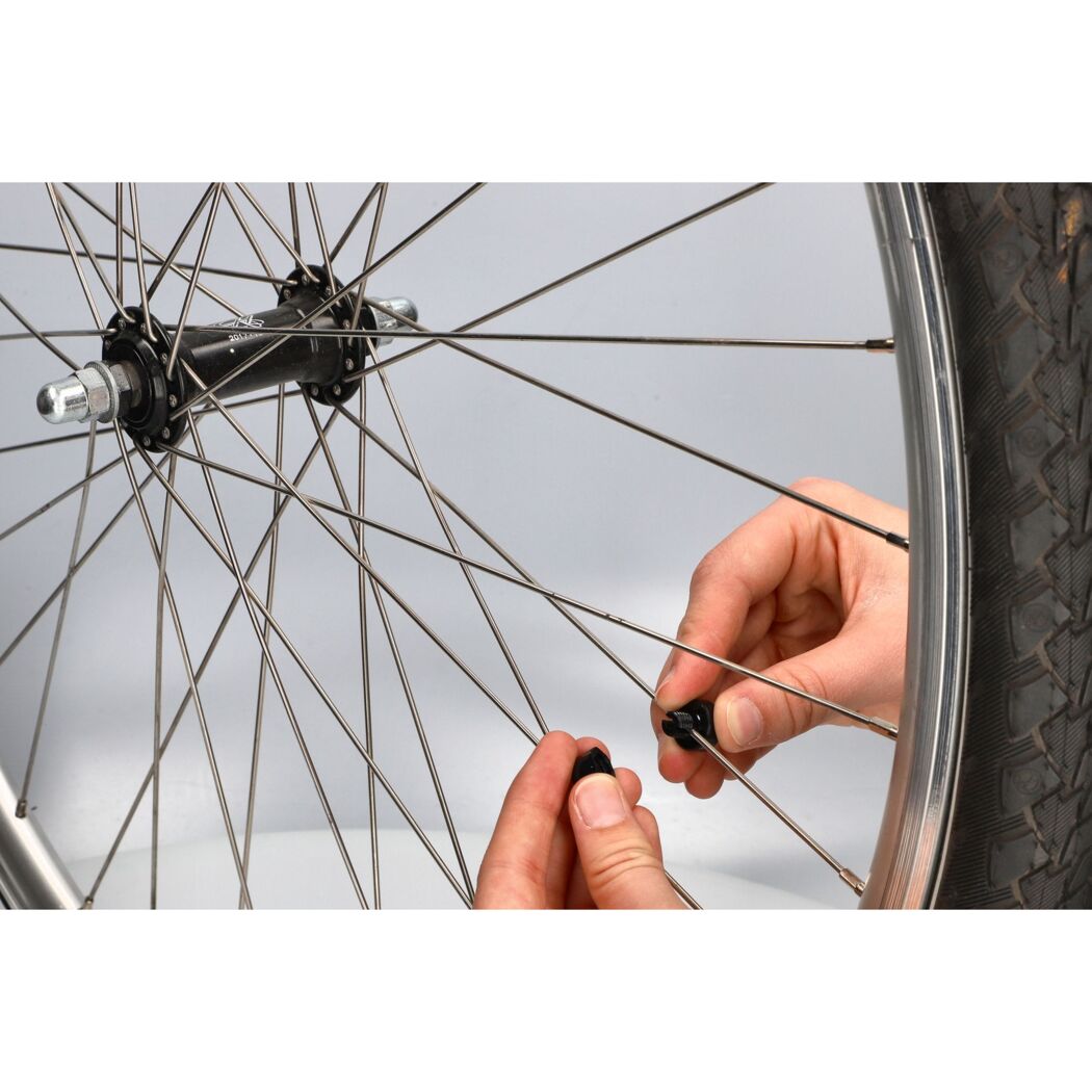 Hände befestigen Sensor an Fahrradspeichen