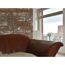 Ledersofa vor Backsteinwand