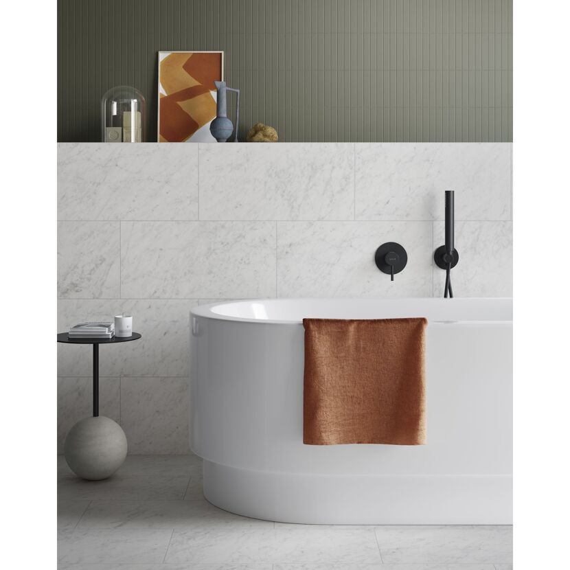Badezimmer mit freistehender Badewanne, Handbrause und Marmorfliesen