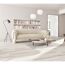 Wohnzimmer mit hellem Sofa, Bücherregal, Couchtisch und Stehlampe