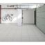 Garage mit Fliesenboden und Fahrrad an der Wand.