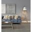 Wohnzimmer mit blauer Couch, gemusterten Kissen und Stehlampe