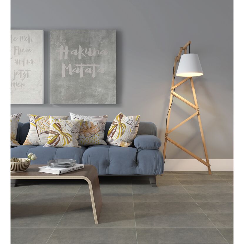 Wohnzimmer mit blauer Couch, gemusterten Kissen und Stehlampe