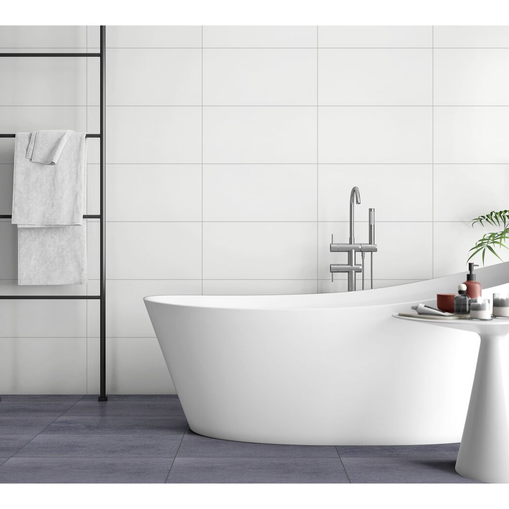 Badezimmer mit weißer Badewanne und grauen Fliesen