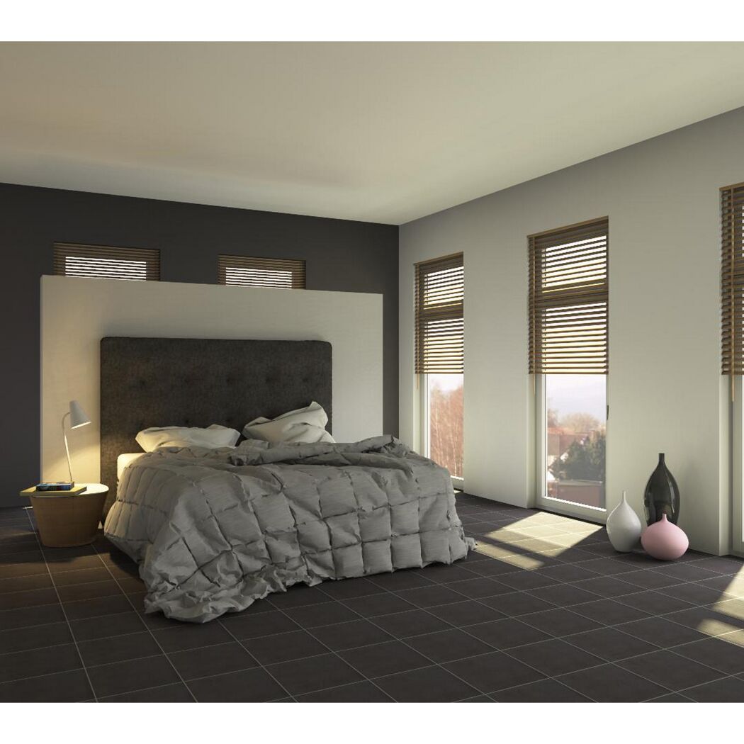Modernes Schlafzimmer mit grauem Bett und dunklen Fliesen