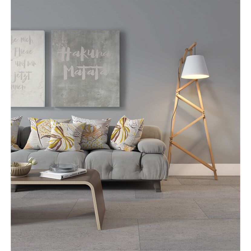 Wohnzimmer mit grauer Couch, gemusterten Kissen und Stehlampe