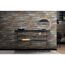 Schwarzes Regal vor Wand mit Steinoptik