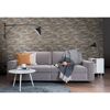 Graues Sofa vor Steinwand
