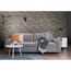Graues Sofa vor Steinwand