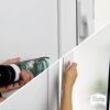 Person verwendet Sista Dichtmittel an einem Fensterrahmen.