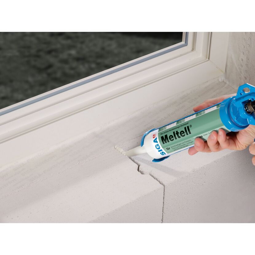 Person verwendet Dichtstoffpistole für Fensterrahmen mit SIGA Meltell.