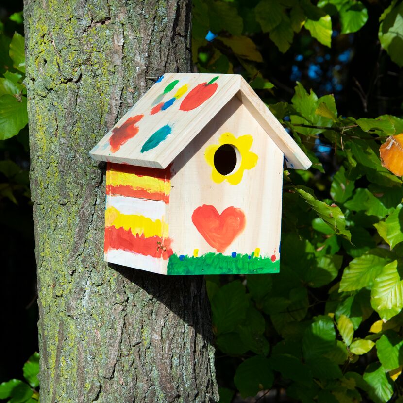 Bunter, bemalter Nistkasten an Baum