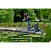 Person reinigt Teich mit Teichschlammsauger.