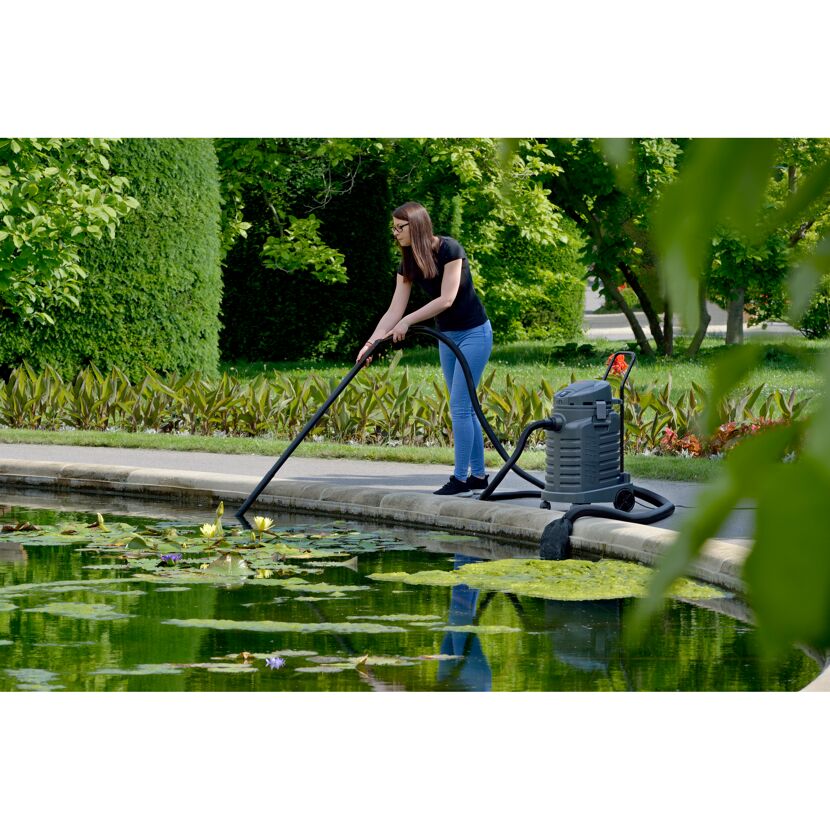 Person reinigt Teich mit Teichschlammsauger.