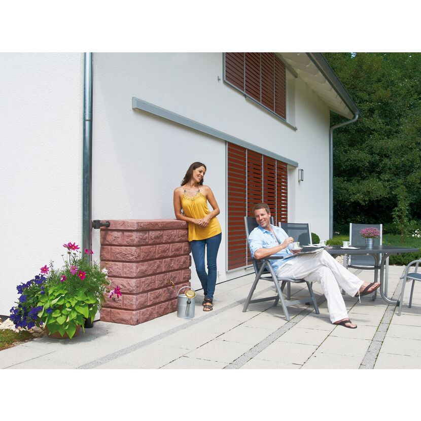 Zwei Personen entspannen auf einer Terrasse mit einem Regenwassertank.