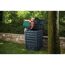 Person füllt Gartenabfälle in einen Komposter.