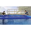 Zwei Personen decken einen Pool mit einer blauen Wärmeplane ab.