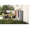 Familie sitzt auf Gartenmöbeln neben einem Säulentank.