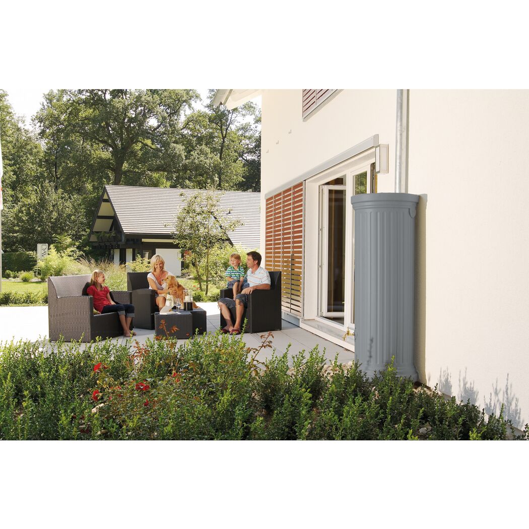Familie sitzt auf Gartenmöbeln neben einem Säulentank.